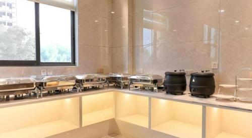 a large kitchen with a bunch of pans at Vatica Hotel Hefei Yaohai Longgang Subway Station in Hefei