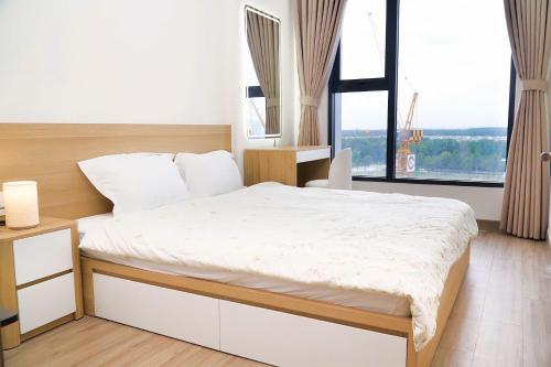 een slaapkamer met een bed en een groot raam bij KNV Apartment in Thu Dau Mot