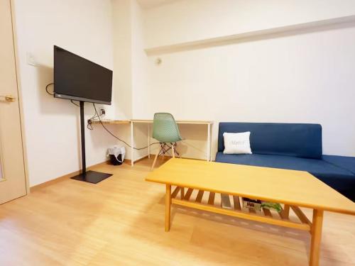 a living room with a blue couch and a table at 2-1新規OPEN！札幌駅7分！SAPPOROステーション美室 in Sapporo