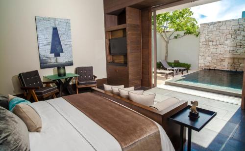 a bedroom with a large bed and a swimming pool at NIZUC Resort & Spa in Cancún