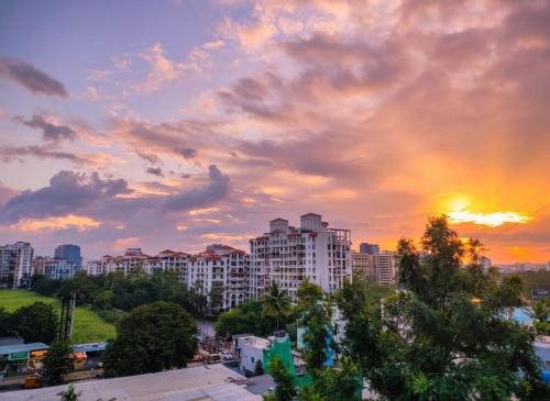 un coucher de soleil sur une ville avec des bâtiments et des arbres dans l'établissement Entire Home in Pune City Near Airport India 3BHK, à Jāmb