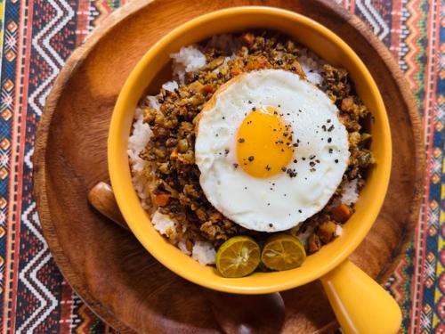 a bowl of rice with an egg on top at Nautilus Hostel & Hammocks in Panglao