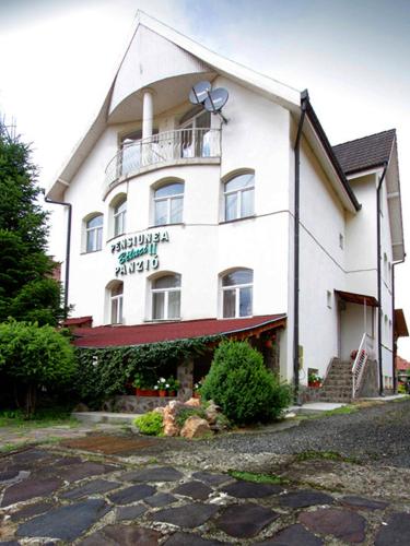 a large white building with a sign on it at Béluci Panzió in Odorheiu Secuiesc