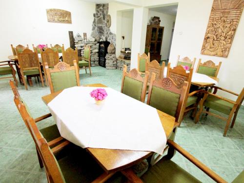 a dining room with a white table and chairs at Béluci Panzió in Odorheiu Secuiesc