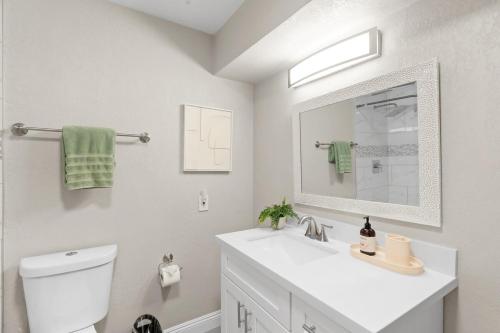 a white bathroom with a sink and a mirror at Heated Saltwater Pool I Old Town I BBQ I Firepit in Scottsdale