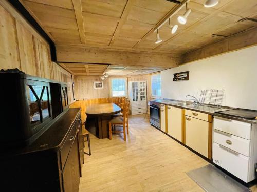 a large kitchen with a wooden ceiling and a table at Ferienhaus Unteraxen in Sisikon