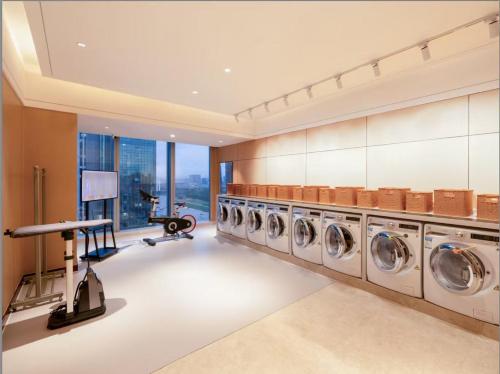 a large laundry room with four washer and dryers at Shangri-La Yiwu in Yiwu