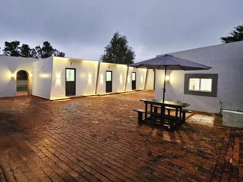 - une terrasse avec une table de pique-nique et un parasol dans l'établissement Beds Inn Midrand, à Midrand