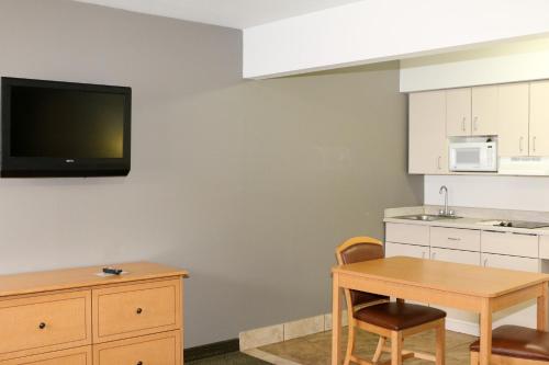 a kitchen with a table and a tv on a wall at Studio 6-Lubbock, TX - Medical Center in Lubbock