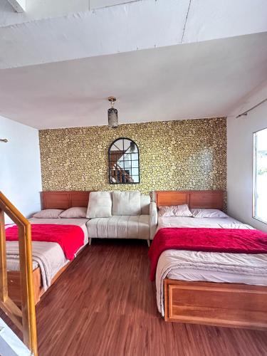 Un dormitorio con dos camas y un sofá. en Rahayu Cabin Villa, en Diyeng