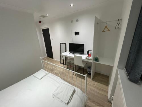 a bedroom with a bed and a desk with a computer at White Rose Hotel & Restaurant - Leeds in Leeds