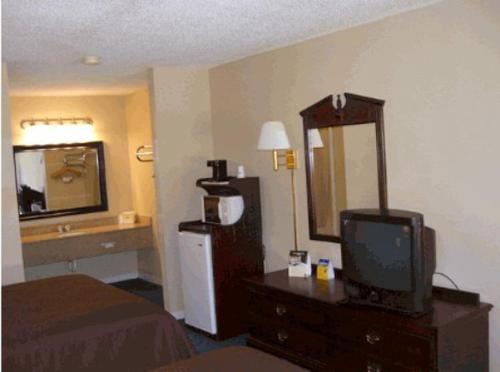 a hotel room with a bed and a television at Americas Best Value Inn Hazlehurst in Hazlehurst