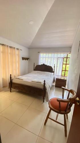 une chambre avec un grand lit et une chaise dans l'établissement Casa campestre Finca Renacer, à San Francisco
