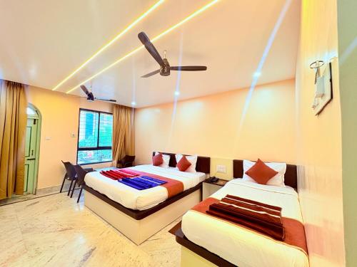 um quarto com duas camas e um ventilador de teto em বীণাপানি হোটেল & রেস্টুরেন্ট Binapani Tarapith em Tarapith