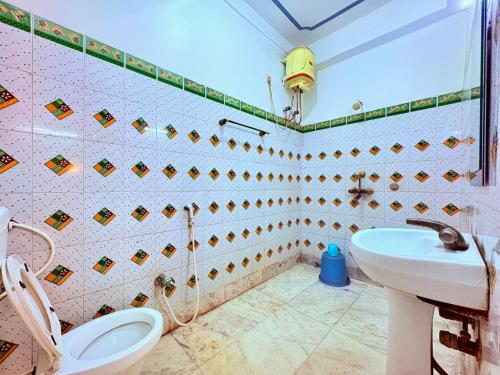 a bathroom with a toilet and a sink at বীণাপানি হোটেল & রেস্টুরেন্ট Binapani Tarapith in Tarapith