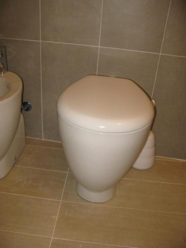 a bathroom with a white toilet and a sink at Gioeni 23 in Cefalù