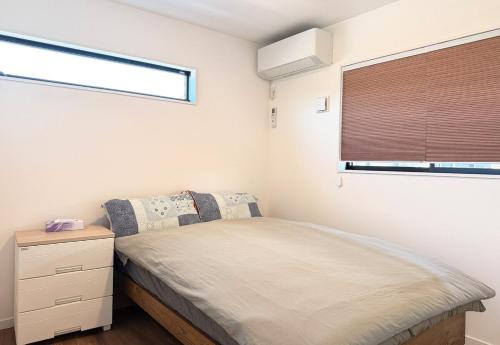 Un dormitorio pequeño con una cama y una ventana. en The Ogawa 小川 Live like a local, en Inzai