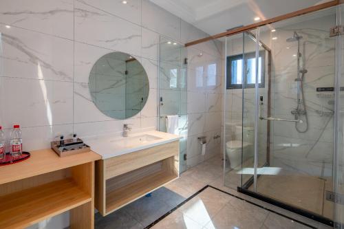 a bathroom with a sink and a glass shower at Meiwan Inn in Jiaxing