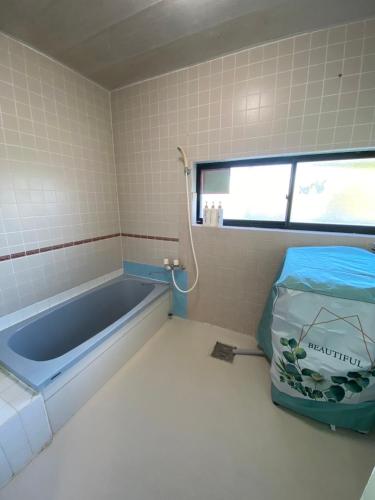 a bathroom with a bath tub in a room at Lagoon藍yoron 一棟貸し in Yoron