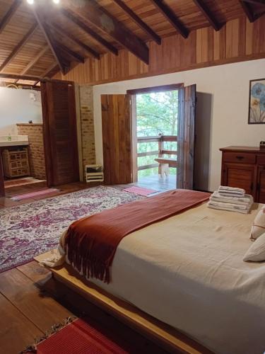 a large bedroom with a large bed and a fireplace at Bangalô Rústico Duplex - Retiro Andaluz in Brumadinho