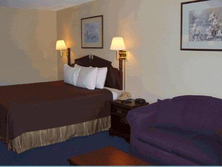 a hotel room with a bed and a couch at Americas Best Value Inn Hazlehurst in Hazlehurst