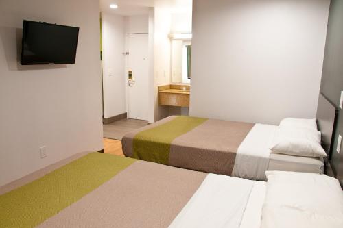 a hotel room with two beds and a flat screen tv at Studio 6-Portland, OR in Parkrose