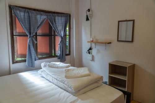 Un dormitorio con una cama con ventana y espejo. en Easy house, en Pai