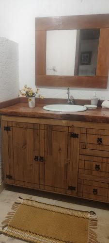 a bathroom with a sink and a mirror at Bangalô Rústico Duplex - Retiro Andaluz in Brumadinho