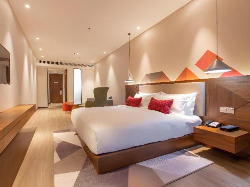 a bedroom with a large white bed with red pillows at Borrman Hotel Guilin Railway Station Two Rivers and Four Lakes in Guilin