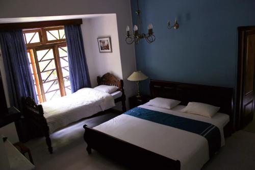 a bedroom with two beds and a window at Hotel Mount Pleasant in Bandarawela