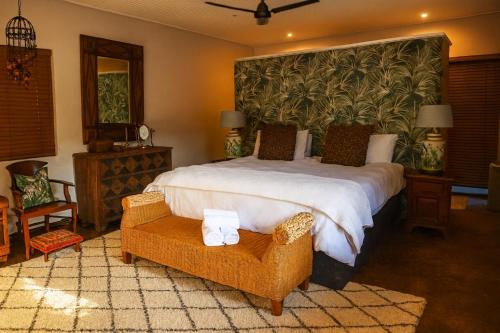 a bedroom with a large bed with a large headboard at Zimbali Emerald Eden in Ballito