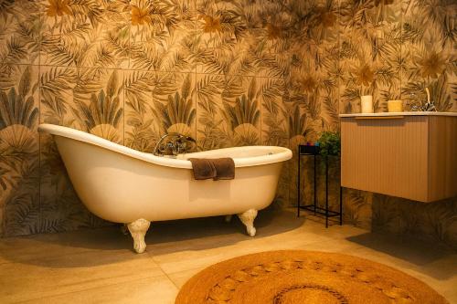 a bath tub in a bathroom with a floral wallpaper at Zimbali Emerald Eden in Ballito