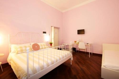 a white bedroom with a bed and a desk at Una Piacevole Sorpresa in Bari