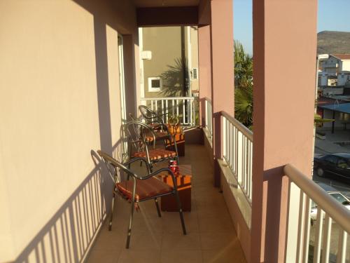 a balcony with chairs and tables on a building at Pansion Alfa in Međugorje