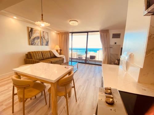 a living room with a table and chairs and the ocean at Newly renovated luxury, modern style Waikiki Sunset Hotel Ocean view Freeparking in Honolulu