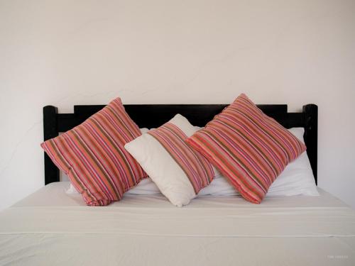 four pillows sitting on top of a bed at Bahari Dhow Beach Villas in Diani Beach