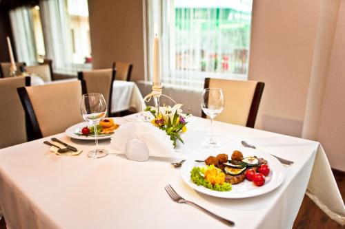 a table with two plates of food and wine glasses at Hotel Kantoria in Tarnów