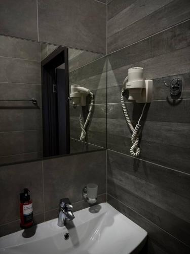 ein Badezimmer mit Waschbecken, Spiegel und Telefon in der Unterkunft Hotel DoZari in Korostyshiv