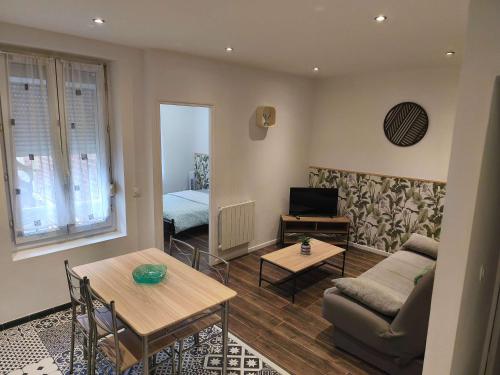 a living room with a couch and a table at Budget Studio avec Parking in Charleville-Mézières