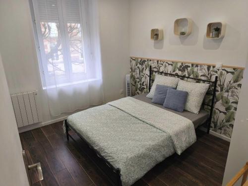 a bedroom with a bed with blue pillows and a window at Budget Studio avec Parking in Charleville-Mézières