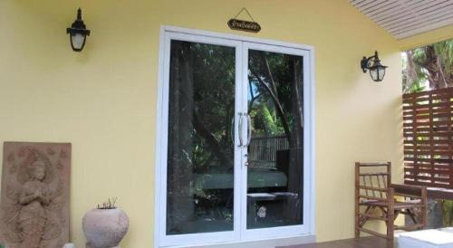 Zimmer mit einer Glasschiebetür zur Terrasse in der Unterkunft Baan Suan Phidchamika in Ban Wat Bot