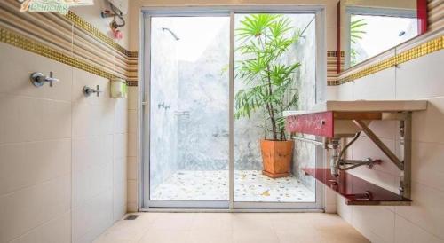 ein Bad mit einer Dusche und ein Fenster mit einer Pflanze in der Unterkunft Phutara Resort in Ban Bang Non Nai