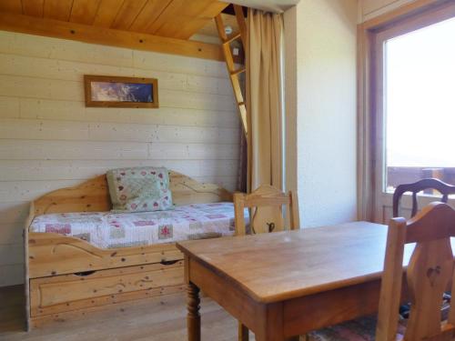 - une chambre avec des lits superposés, une table et une table à manger dans l'établissement Résidence Mont Vallon, à Méribel