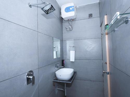 ein kleines Badezimmer mit Waschbecken und Dusche in der Unterkunft Saswata Hotels By Kamay Group in Ayodhya