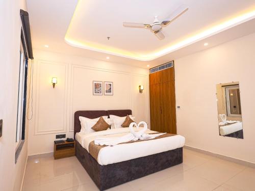 ein Schlafzimmer mit einem Bett mit Deckenventilator in der Unterkunft Saswata Hotels By Kamay Group in Ayodhya