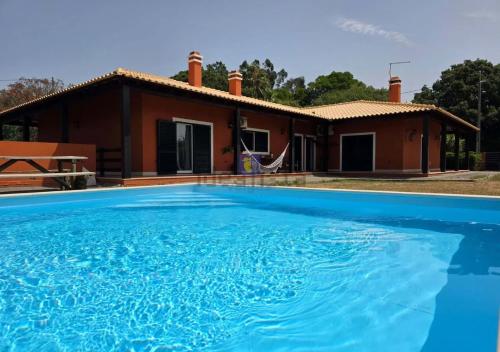 a house with a swimming pool in front of a house at A casa das minhas netas in Caldas da Rainha