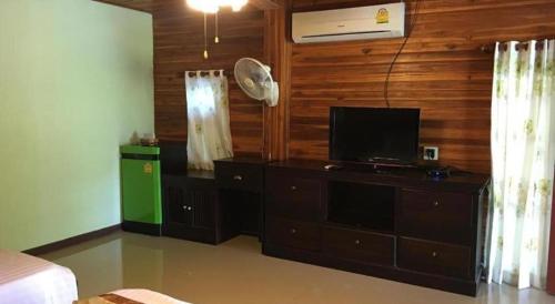 a bedroom with a tv and a dresser with a tvictericter at Ban Noi Resort Phrae in Sop Sai