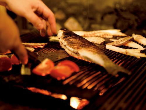 a person is cooking food on a grill at Jet Hotel in Caselle Torinese