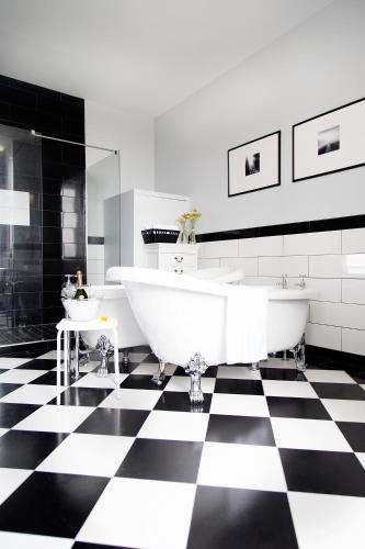 a bathroom with two tubs on a black and white checkered floor at Chateau De Jalesnes in Vernantes