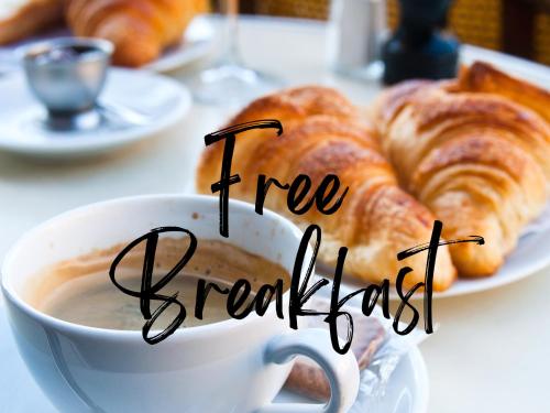 a cup of coffee and a plate of croissants at Séjour romantique ou professionnel au Château isigny, Charme et feu de cheminée in Isigny-le-Buat